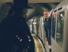 a man standing next to a subway train