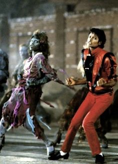 two people in costumes are dancing on the street