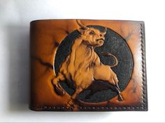 a brown leather wallet with a bull on it