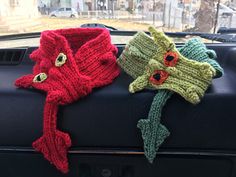 two knitted hats sitting on the back of a car seat next to each other