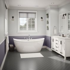 a white bath tub sitting in a bathroom next to a sink and toilet under a window