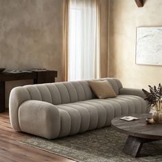 a living room with a couch, coffee table and rug in front of the window