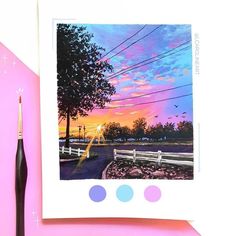 a painting of a sunset on a pink background with a black brush next to it