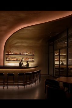 a dimly lit bar with stools in front of it