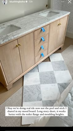 a bathroom vanity with two sinks and blue tape taped to the counter top above it