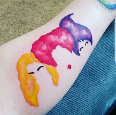 a woman's arm with some watercolors on it and her face painted like princesses