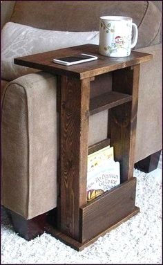 a coffee table with a book shelf underneath it and a cup sitting on top of it