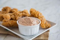 a white plate topped with tater tots and dipping sauce