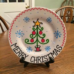 a merry christmas plate sitting on top of a wooden table