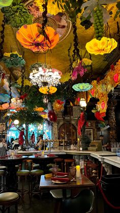 the interior of a restaurant with many colorful umbrellas hanging from the ceiling and chandeliers