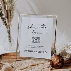 a sign that says share the life next to a vase with dried grass in it