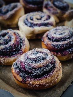 some very tasty looking doughnuts with powdered sugar on top and blueberry filling