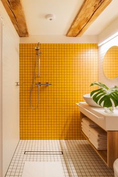 a bathroom with yellow tiles and a white toilet sitting next to a walk in shower