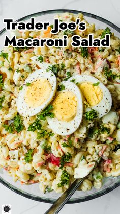 a bowl filled with macaroni salad topped with hard boiled eggs and parsley