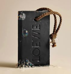 a soap bar with soap bubbles hanging from it's side and the word love spelled in black