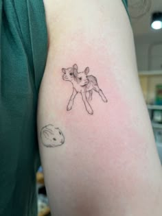 a woman's arm with a small tattoo of a cat and dog on it