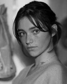 a black and white photo of a woman with freckled hair