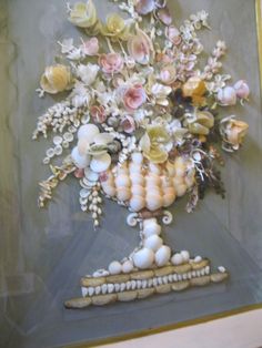 a painting of flowers and shells in a vase on a table next to a wall