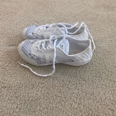 a pair of white shoes with laces on the bottom are laying on the floor