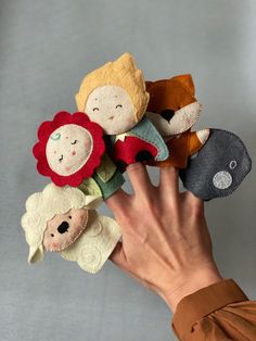 a person holding several small stuffed animals in their hands