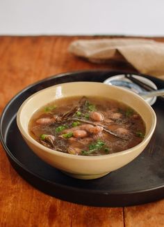 a bowl of soup on a black plate