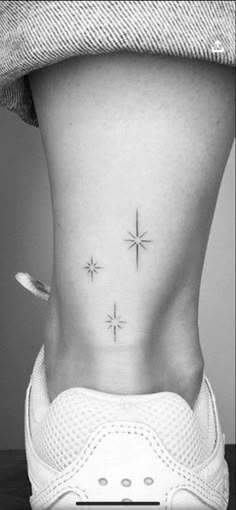 a woman's lower back tattoo with three stars