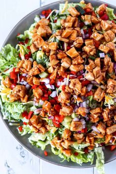 a salad with chicken, lettuce and red onions