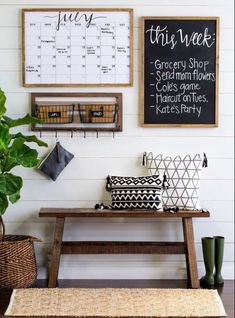 a wooden bench sitting in front of a wall with calendars and plants on it