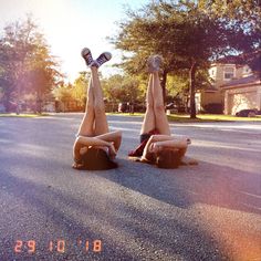 two people laying on their stomachs in the middle of the road with one upside down