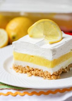 lemon lasagna on a white plate with two lemons in the background and text overlay that reads, lemon lasagna