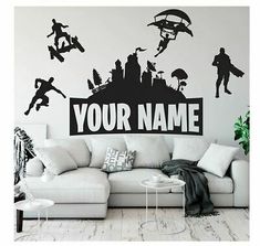 a living room with a white couch and black wall decal that says your name