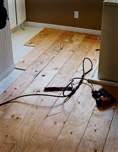 a cord is plugged into an electrical outlet on the floor in front of a door