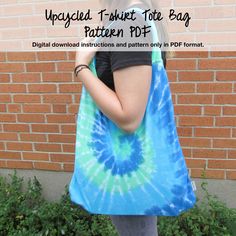 a woman carrying a blue and green tie - dyed tote bag