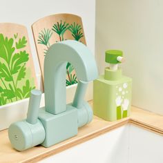 two wooden chairs sitting next to each other on top of a counter with green and white decorations