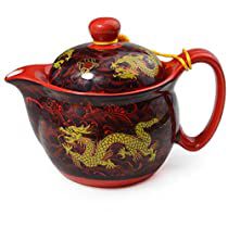 a red and yellow ceramic tea pot with dragon designs on the lid, sitting in front of a white background