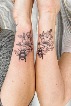 two women with matching tattoos on their legs holding each other's hands and looking at the camera