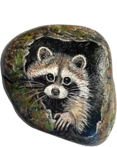 a painted rock with a raccoon on it