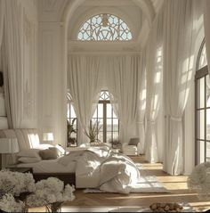 a large bed sitting in the middle of a bedroom next to two windows with white drapes