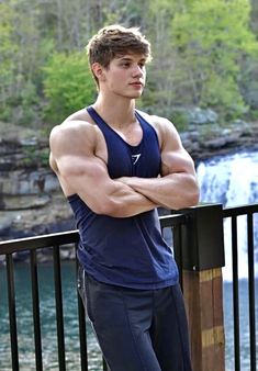 a man with his arms crossed leaning on a railing