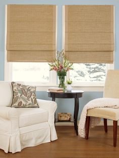 a living room filled with furniture and a window covered in roman blind shades on the windowsill