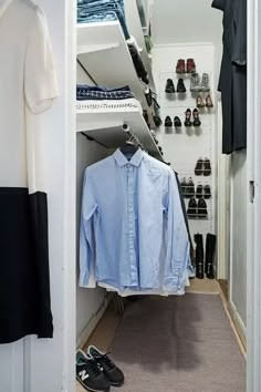 an open closet with shoes and shirts hanging on the shelves next to eachother