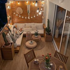 a living room filled with lots of furniture and lights hanging from the ceiling above it