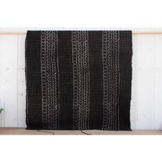 a black and white rug sitting on top of a wooden table next to a plant