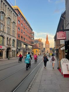 several people riding bicycles down a city street