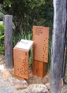 two wooden boxes sitting next to each other on top of a dirt ground near trees