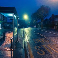 an empty city street at night with the lights on and no one is in sight