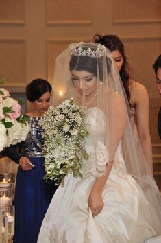 the bride is getting ready to walk down the aisle with her bouquet in front of her