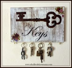 a wooden sign with keys hanging from it's sides