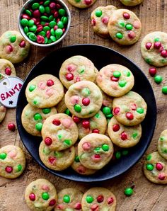 a plate full of cookies with green and red sprinkles next to a bowl of candy