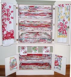 an open cabinet filled with lots of colorful fabric